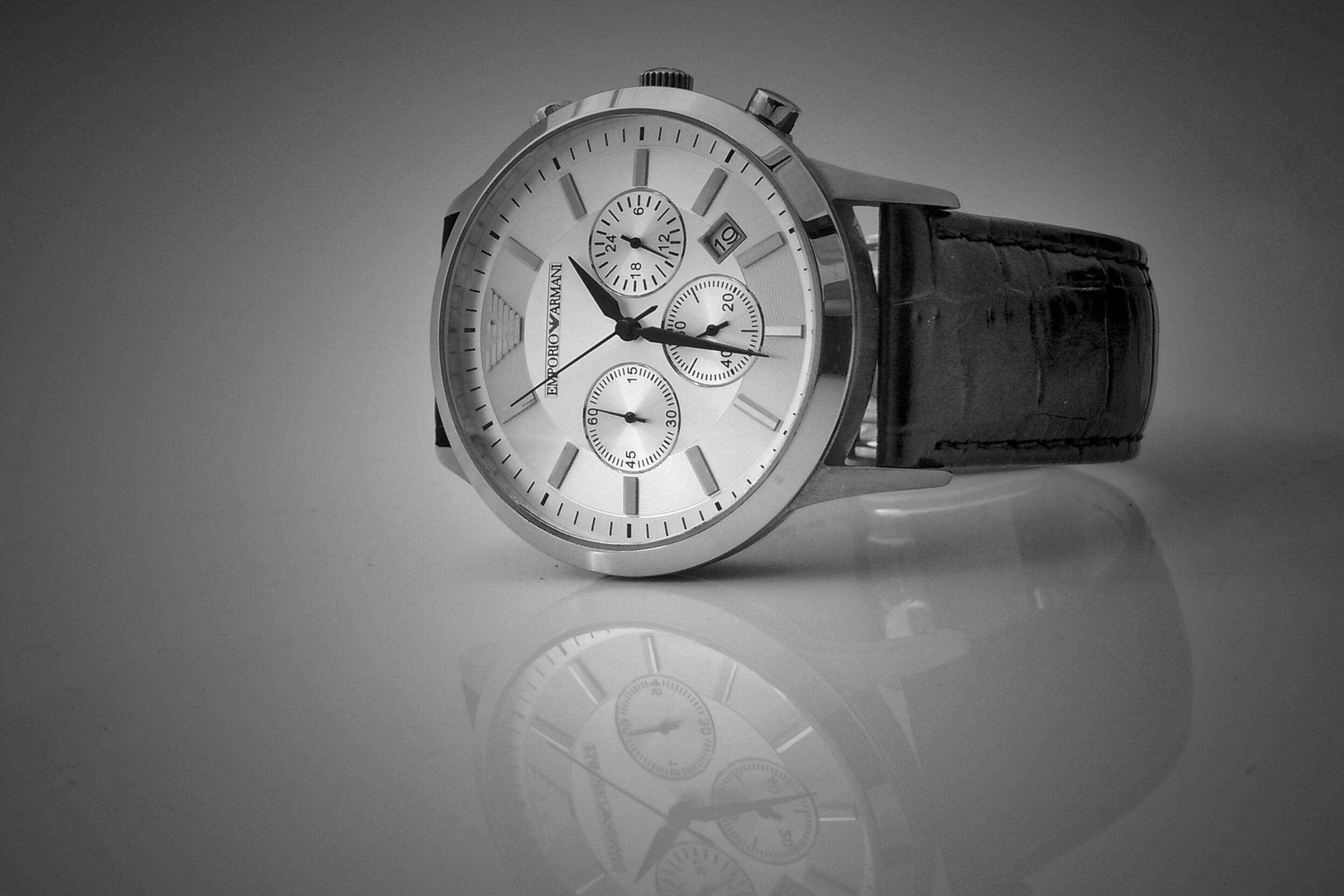 A watch, with its reflection on the table