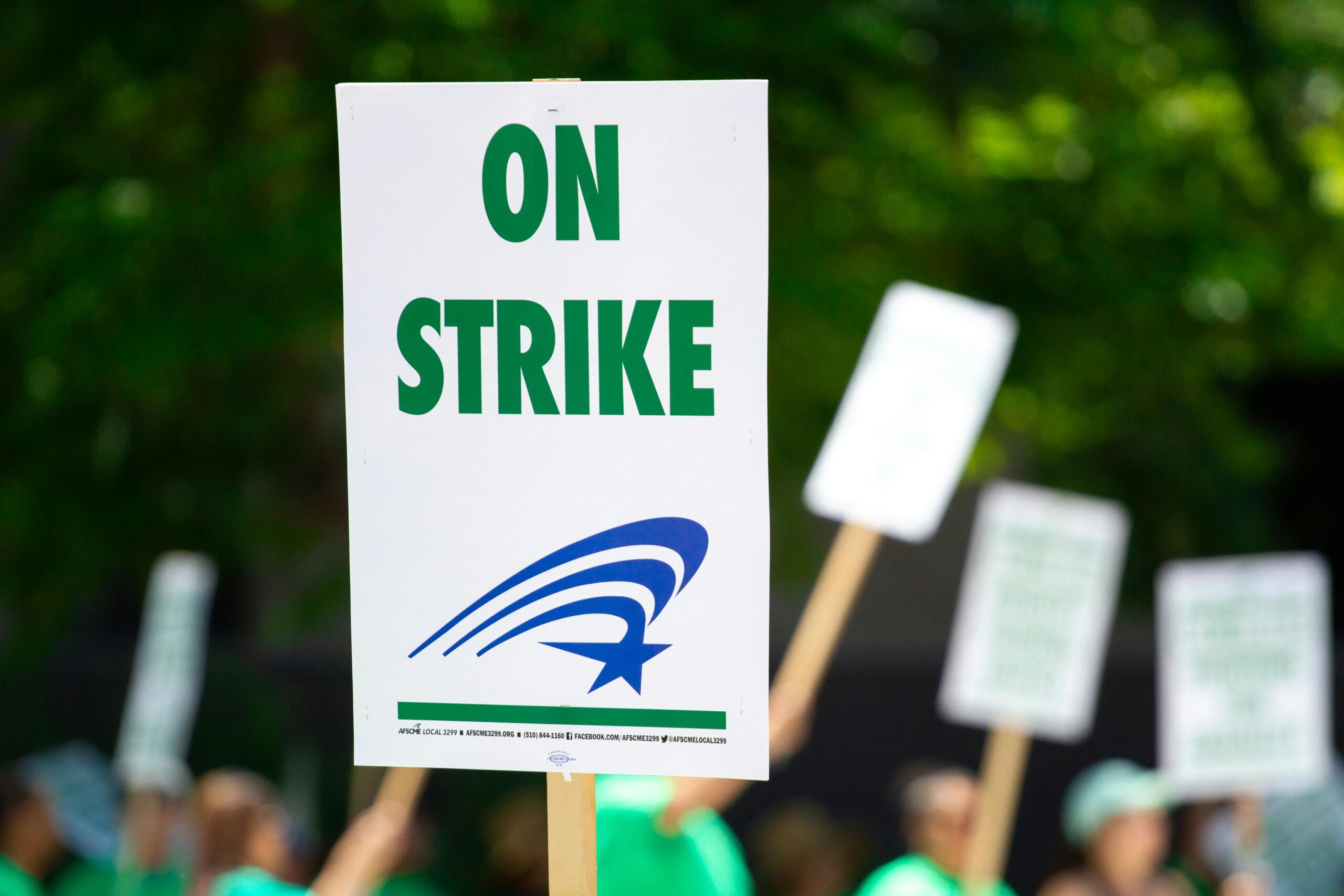 A picket line with signs reading "On Strike"