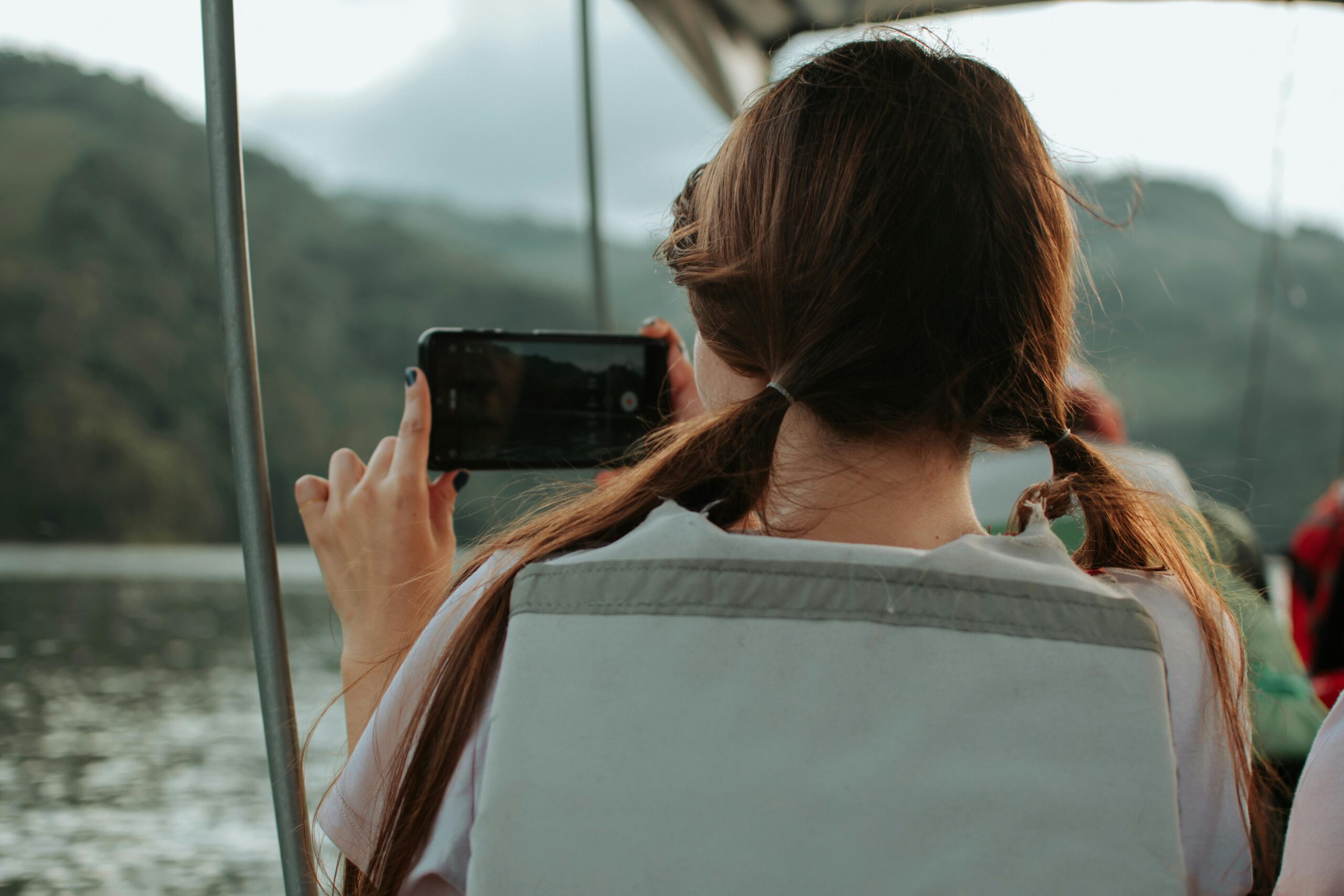 Woman on a boat, recording with her phone