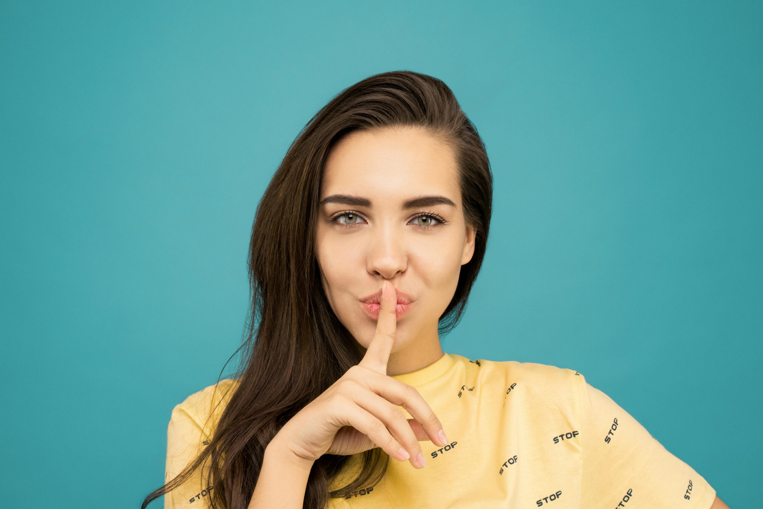 Woman putting her finger to her lips in a shushing motion